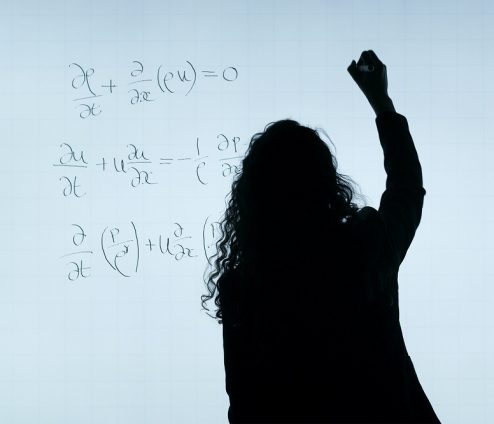 Vrouw schrijft wiskundige formules op whiteboard